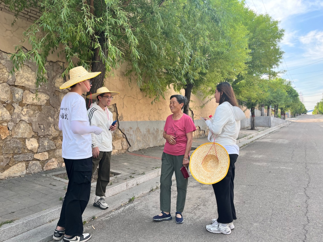 國(guó)土整治與生態(tài)修復(fù)實(shí)踐調(diào)研團(tuán)師生與村民交流。校方供圖